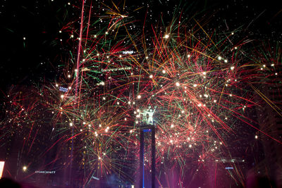 Low angle view of fireworks against sky at night