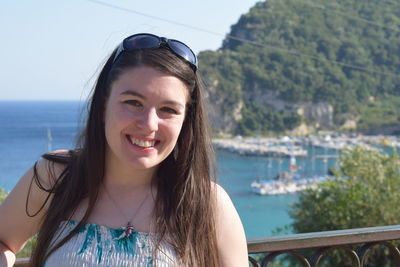 Portrait of smiling young woman against sea