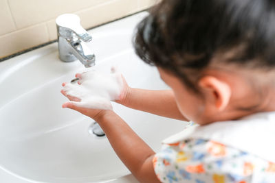 Side view of boy washing hands