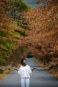 Full length of young woman standing on road