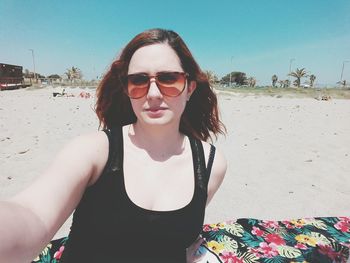 Portrait of young woman wearing sunglasses on beach