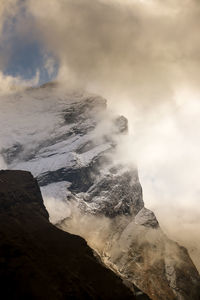 Aerial view of volcanic mountain against cloudy sky