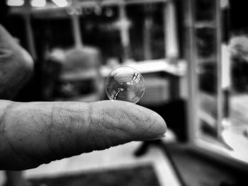 Close-up of hand holding glass ball