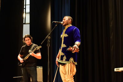 Young man playing guitar at music concert