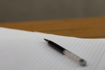 Close-up of pen on book at table