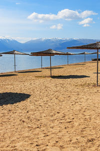 View of calm beach against cloudy sky