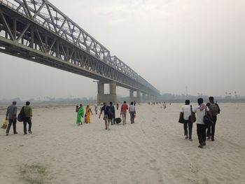 People walking on bridge against sky