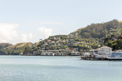 Scenic view of sea by buildings against sky