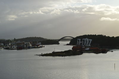 Bridge over river against sky in city