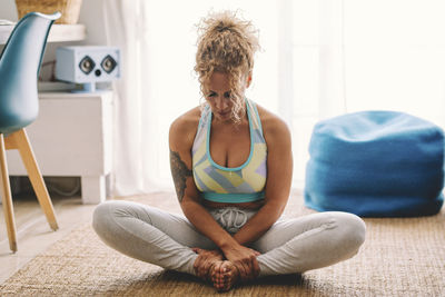 Side view of young woman exercising at home