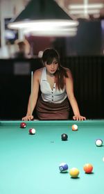 Young woman playing pool