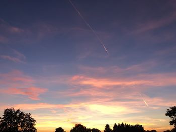 Low angle view of silhouette trees against sky at sunset