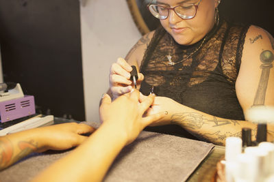 A beautician giving a customer a manicure.