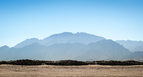 Scenic view of mountains against clear blue sky