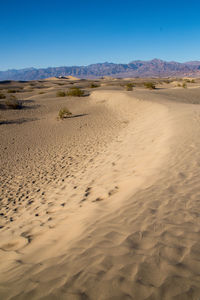 Scenic view of desert against clear blue sky