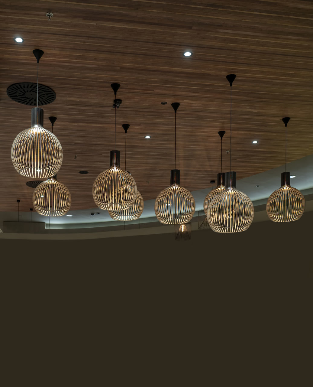 LOW ANGLE VIEW OF ILLUMINATED PENDANT LIGHTS