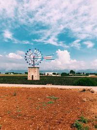 Traditional windmill on field against sky on mallorca