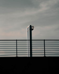 Close-up of metallic structure against sky at sunset