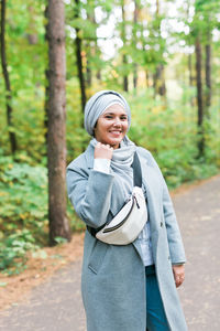 Portrait of smiling young woman in forest