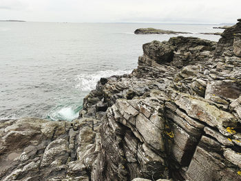Rock formation on beach against sky