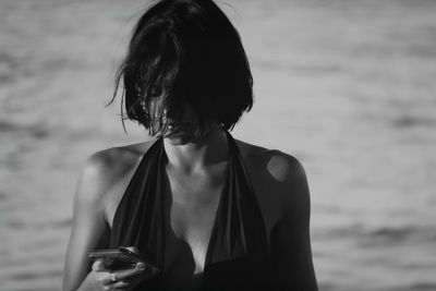 Side view of young woman looking away at beach