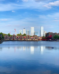 River by buildings against blue sky