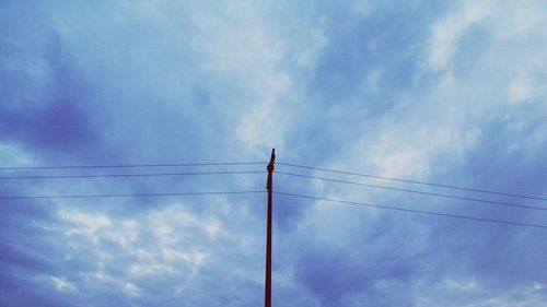 Low angle view of power lines against blue sky