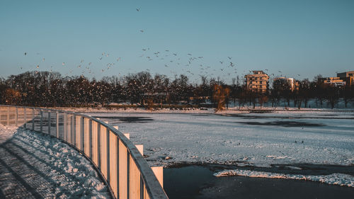 Bridge over river against clear sky during winter