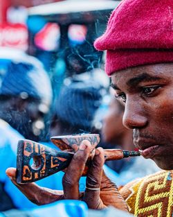 Side view of young man smoking cigarette