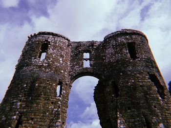 Low angle view of old built structure against cloudy sky