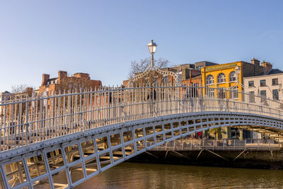 Bridge over river against buildings in city