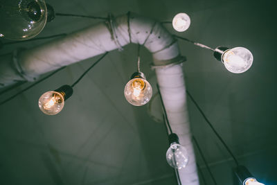 Low angle view of light bulbs hanging from ceiling