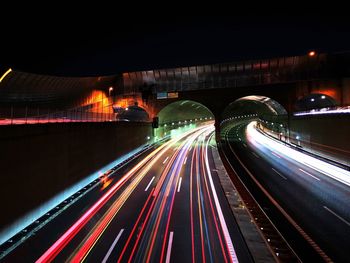 Light trails on bridge in city at night