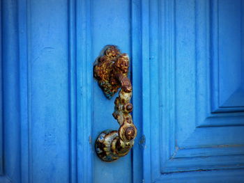 Rusty metal handle on blue door