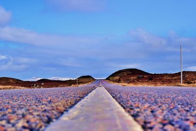 Surface level of road against blue sky