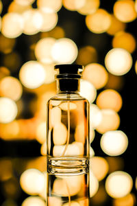 Plain perfume bottle with sparkling lights bokeh background