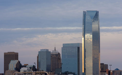 Modern cityscape against sky during sunset