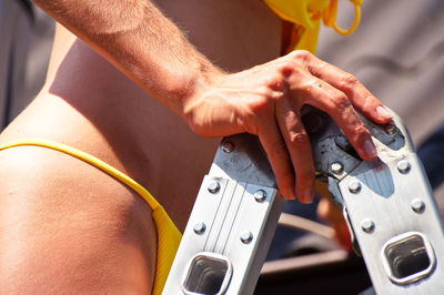 Midsection of woman climbing ladder