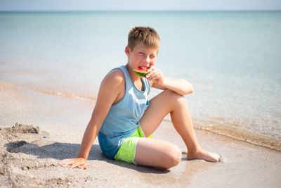 Portrait of young woman sitting on beach