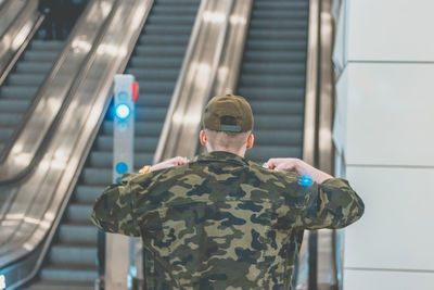 Rear view of man standing against railing