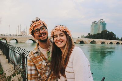 Portrait of young couple smiling behind old stone bridge of adana turkey