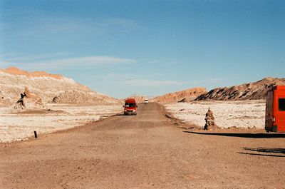 Cars on road amidst desert against sky