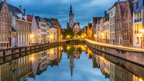 Reflection of buildings in canal at dusk