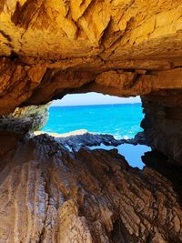 Scenic view of sea seen through cave