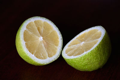 Close-up of lemon slice on table against black background