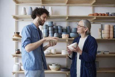 Man and woman discussing over bowl in pottery class