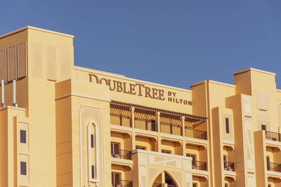 Low angle view of buildings against clear blue sky