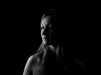 Portrait of woman against black background