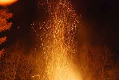 Close-up of illuminated fireworks against sky at night