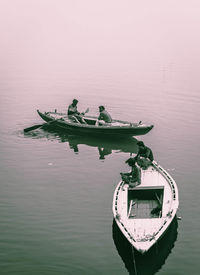 Fishing boat sailing in lake against sky